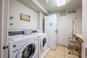 Shared laundry featuring washing machine and dryer and stacked washer and dryer