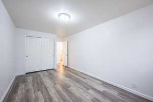 Unfurnished bedroom featuring dark wood finished floors and a closet