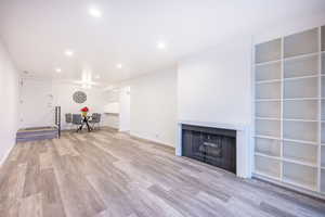 Unfurnished room featuring light wood-style floors, a fireplace, and recessed lighting