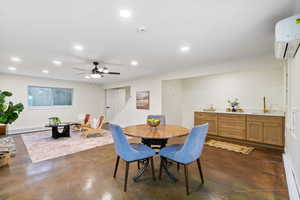 Dining space featuring concrete flooring, a ceiling fan, recessed lighting, and a baseboard heating unit