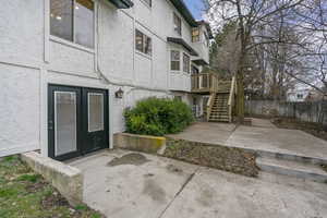 Rear view of property with a patio, stucco siding, and french doors