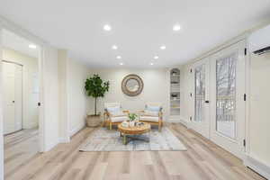 Living area with recessed lighting, light wood-style flooring, and built in shelves