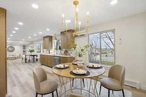 Dining area with a chandelier and light wood-style flooring