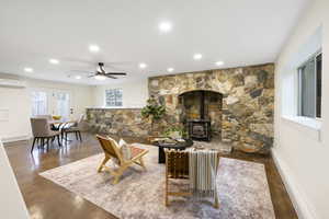 Living area featuring ceiling fan, finished concrete floors, a wood stove, and recessed lighting