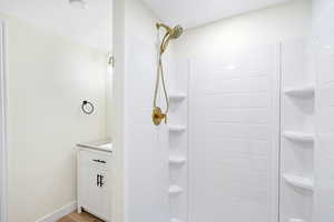Full bathroom featuring vanity, a shower stall, and light wood-style flooring