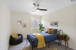 Carpeted bedroom featuring crown molding and a ceiling fan