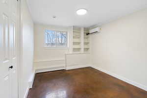 Unfurnished bedroom featuring finished concrete floors, a closet, crown molding, and a baseboard radiator