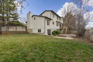 Rear view of property featuring a fenced backyard, a chimney, a patio, stucco siding, and a deck