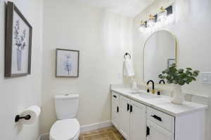 Half bathroom featuring vanity and toilet