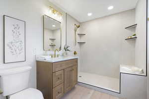 Bathroom featuring vanity, walk in shower, light wood-style floors, and recessed lighting