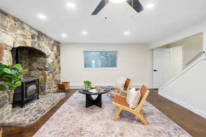 Living area with a wood stove, ceiling fan, and recessed lighting