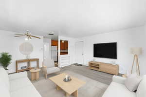 Living room with wood finished floors and a ceiling fan