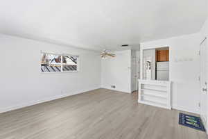 Unfurnished living room with light wood-type flooring and a ceiling fan
