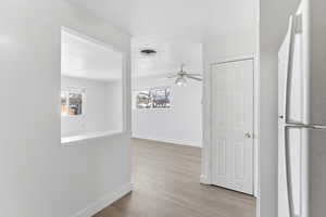 Corridor with light wood finished floors and plenty of natural light