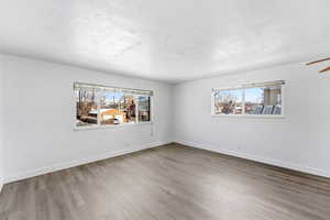 Empty room with light wood-type flooring and a textured ceiling