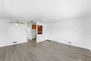 Unfurnished living room with a ceiling fan and light wood-type flooring