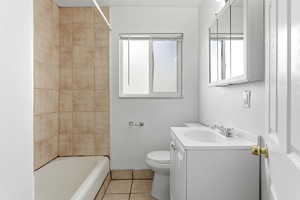 Full bathroom featuring vanity, light tile patterned flooring, healthy amount of natural light, and washtub / shower combination