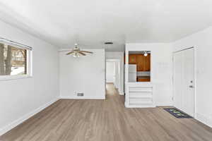 Unfurnished living room with a ceiling fan and light wood finished floors
