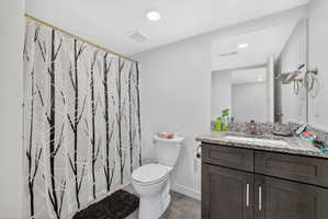 Bathroom with vanity, recessed lighting, wood finished floors, and shower / tub combo with curtain