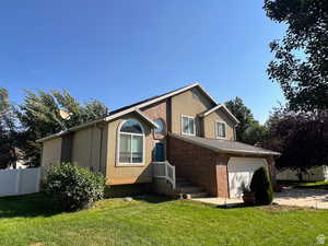 View of front facade featuring stucco siding, brick siding, an attached garage, and concrete driveway