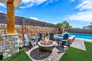 Fenced backyard featuring an outdoor fire pit and a patio