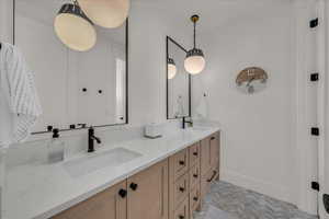 Bathroom featuring double vanity and baseboards