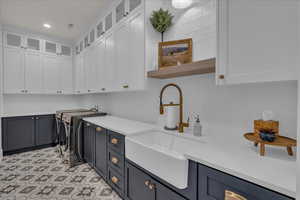 Laundry room with washing machine and clothes dryer, cabinet space, and recessed lighting
