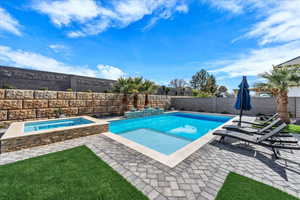 Combined pool / hot tub featuring a patio and a fenced backyard