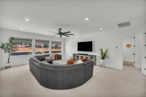 Living area with light colored carpet, recessed lighting, and ceiling fan