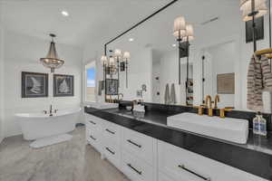 Bathroom featuring double vanity, a soaking tub, and recessed lighting