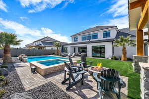 View of pool featuring an outdoor fire pit, patio surround, and a fenced backyard