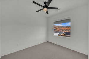 Spare room featuring carpet and a ceiling fan