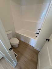 Bathroom featuring light wood finished floors and tub / shower combination