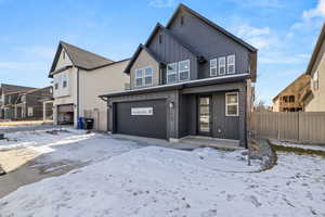 View of front of house with a garage and board and batten siding