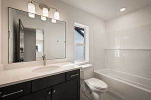 Bathroom with vanity, tub / shower combination, and recessed lighting