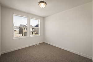 Carpeted spare room with baseboards and a textured ceiling