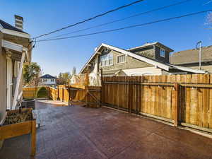 Fenced backyard with a gate, a residential view, and a patio area