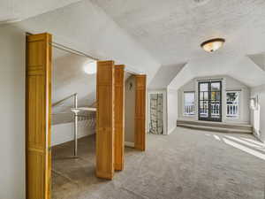 Bonus room featuring light colored carpet and baseboards