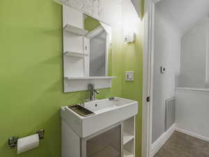 Half bathroom with carpet floors and vanity