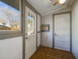 Doorway to outside with vaulted ceiling, a ceiling fan, and tile patterned flooring