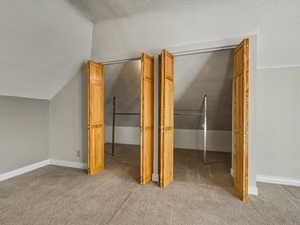 Additional living space featuring light carpet and baseboards