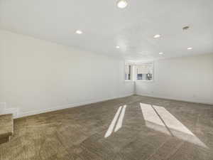 Carpeted empty room featuring recessed lighting and a textured ceiling