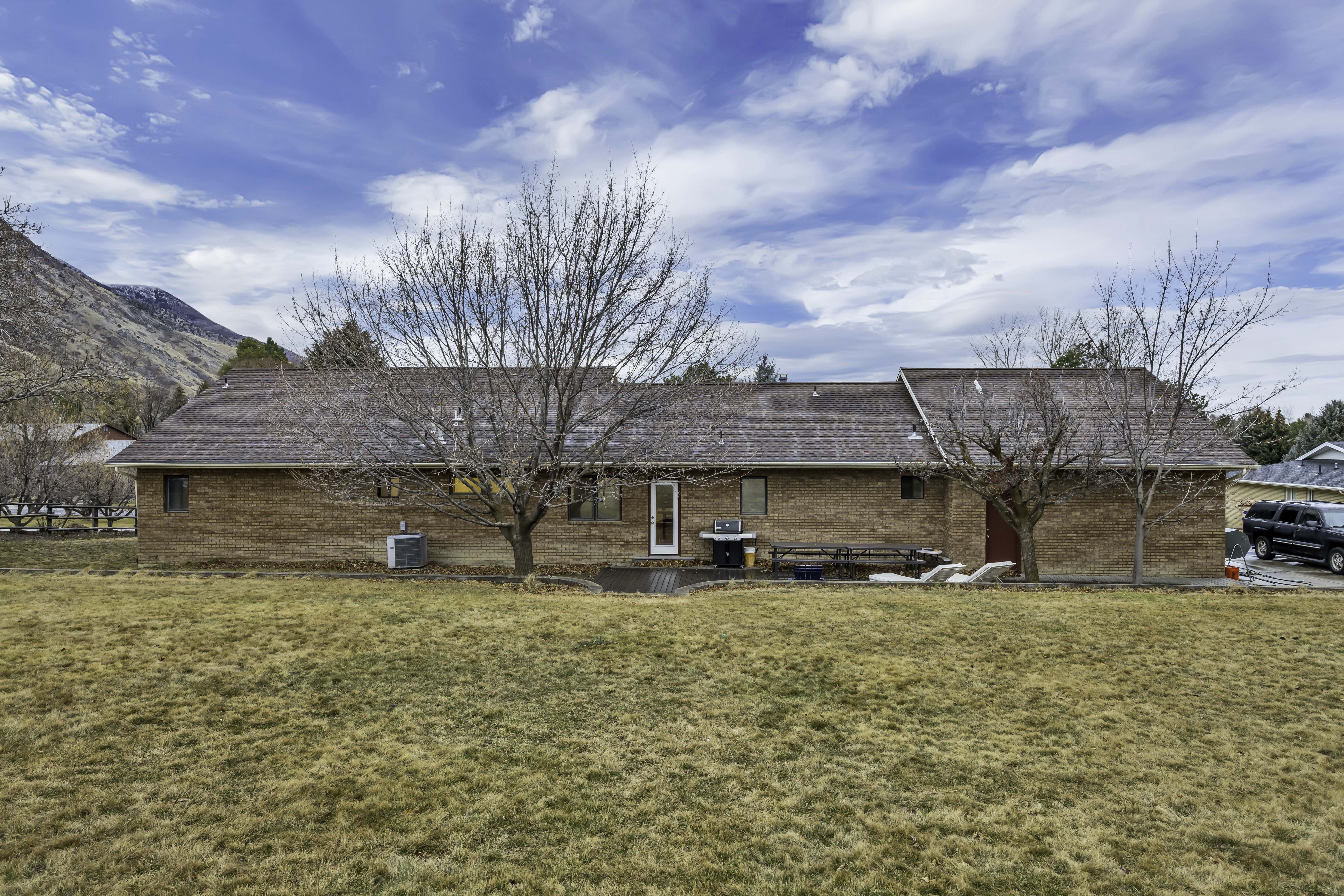 Rear view of property with a patio area, brick siding, and a yard
