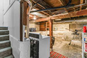 Unfinished below grade area featuring stairway