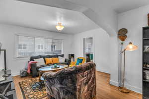 Living area with arched walkways and light wood finished floors