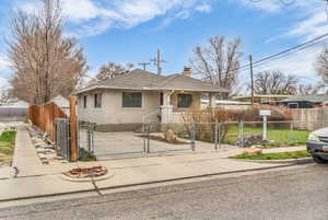 Bungalow with roof with shingles, brick siding, and a fenced front yard