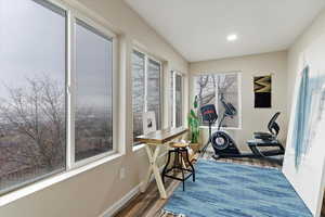 Workout room featuring dark wood-type flooring and baseboards