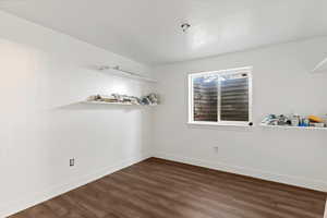 Unfurnished room with dark wood finished floors and baseboards
