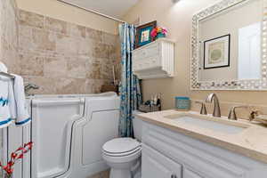 Bathroom featuring vanity, shower / tub combo, and a textured ceiling