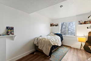 Bedroom with wood finished floors and baseboards